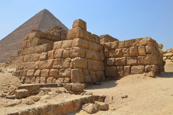 Pyramid in sand dust under gray clouds