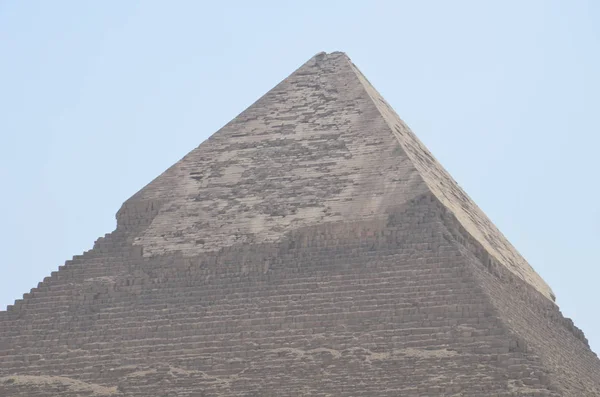 Пирамида в песчаной пыли под серыми облаками — стоковое фото