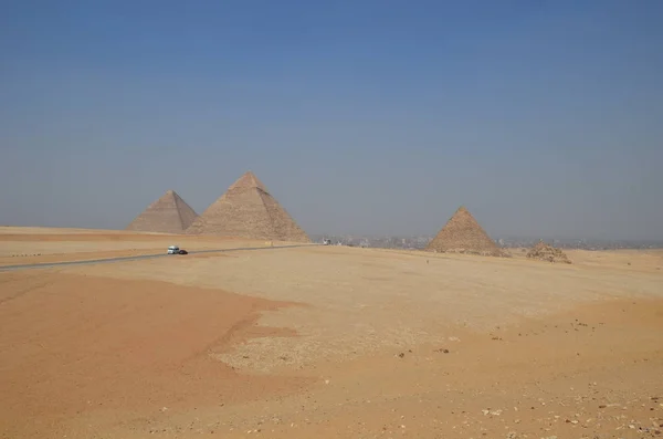 Pyramid in sand dust under gray clouds — Stock Photo, Image