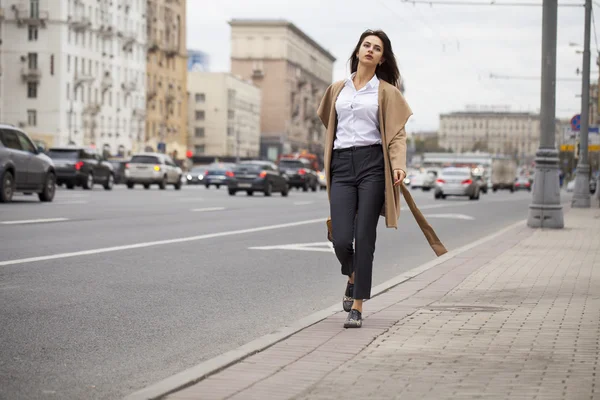 Porträtt av en ung vacker kvinna i beige kappa — Stockfoto