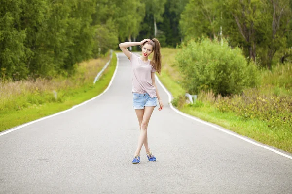 Portrait of young brunette woman in blue jeans short — Stock Photo, Image