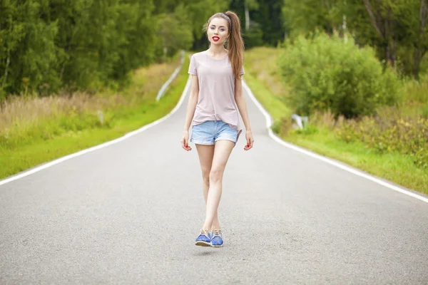 Porträtt av ung brunett kvinna i blå jeans kort — Stockfoto