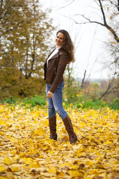 Autumn fashion image of young woman walking in the park — Stock Photo, Image