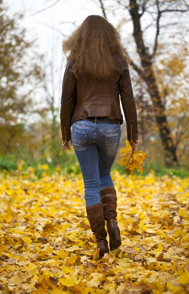 Autumn fashion image of young woman walking in the park — Stock Photo, Image