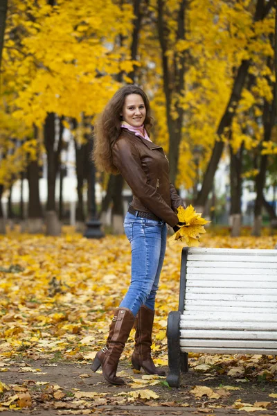 Autumn fashion image of young woman walking in the park — Stock Photo, Image