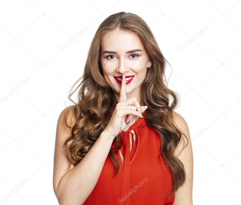 Young beautiful woman has put forefinger to lips as sign of sile
