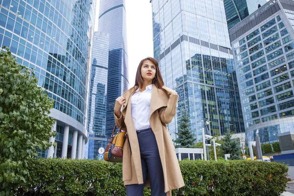 Joven mujer de negocios en el fondo de los rascacielos — Foto de Stock