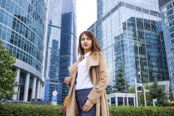 Joven mujer de negocios en el fondo de los rascacielos —  Fotos de Stock