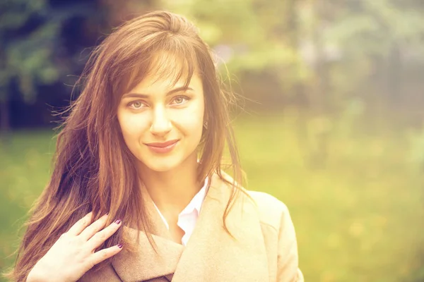 Portrait of a young beautiful woman in beige coat — Stock Photo, Image