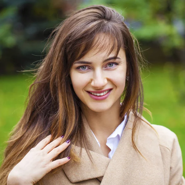Porträtt av en ung vacker kvinna i beige kappa — Stockfoto