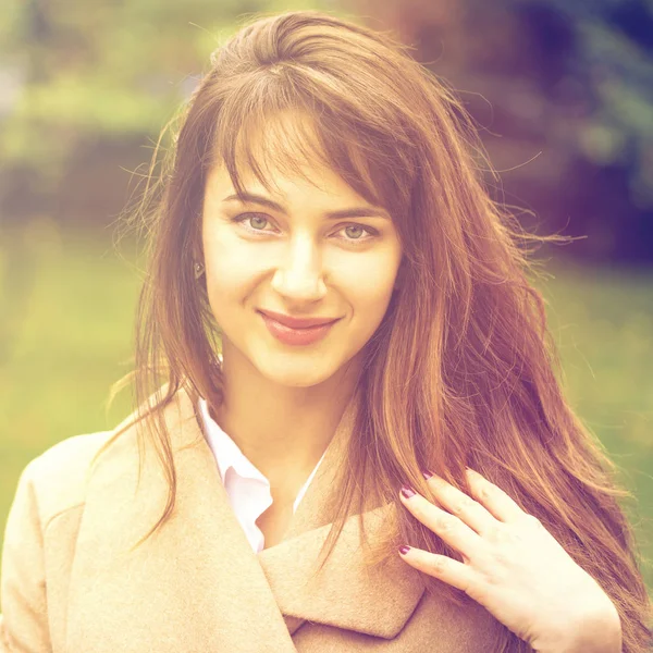 Portret van een jonge mooie vrouw in beige jas — Stockfoto