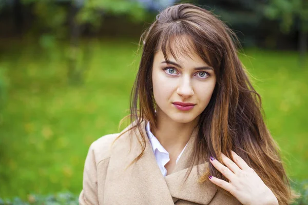 Portret van een jonge mooie vrouw in beige jas — Stockfoto