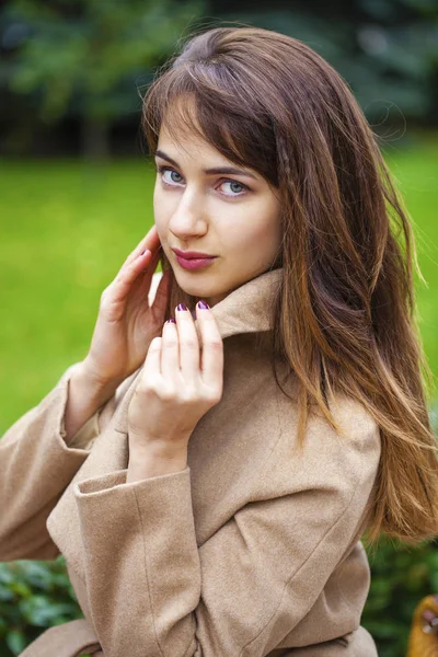Portret van een jonge mooie vrouw in beige jas — Stockfoto