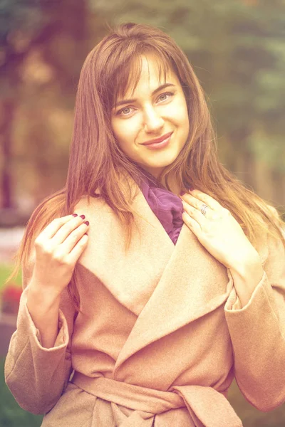 Portrait of a young beautiful woman in beige coat — Stock Photo, Image