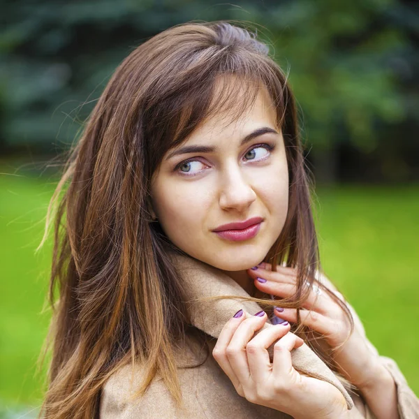 Porträt einer jungen schönen Frau im beigen Mantel — Stockfoto