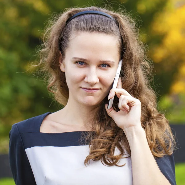 Porträtt av glad ung brunett kvinna i klänning talar på p — Stockfoto