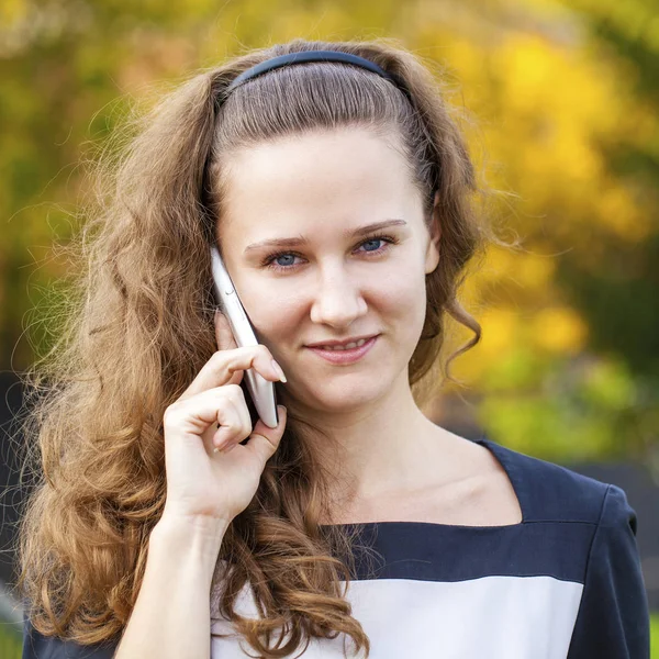 Porträtt av glad ung brunett kvinna i klänning talar på p — Stockfoto