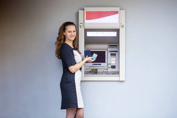 Jeune femme insérant une carte de crédit au guichet automatique — Photo