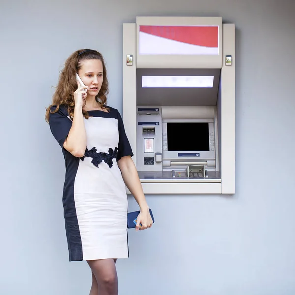 Mujer joven insertando una tarjeta de crédito en el cajero automático —  Fotos de Stock