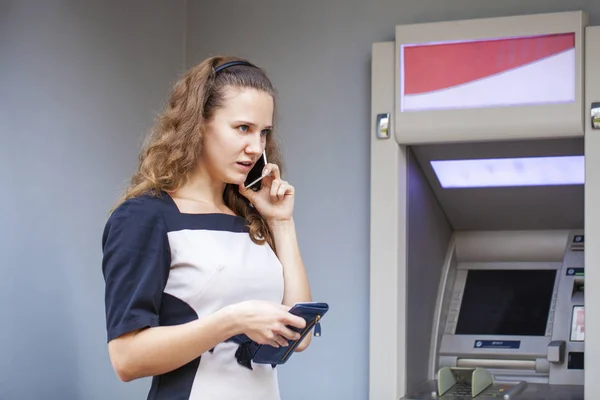 Mujer joven insertando una tarjeta de crédito en el cajero automático —  Fotos de Stock