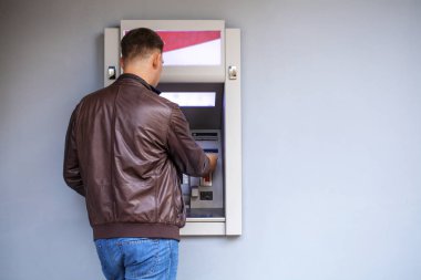 Genç adam bir kredi kartı Atm için ekleme