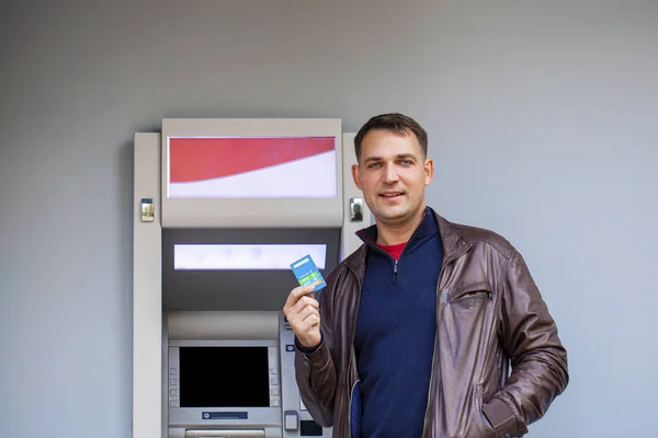 Young man inserting a credit card to ATM — Stock Photo, Image