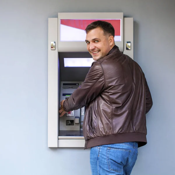 Young man inserting a credit card to ATM — Stock Photo, Image