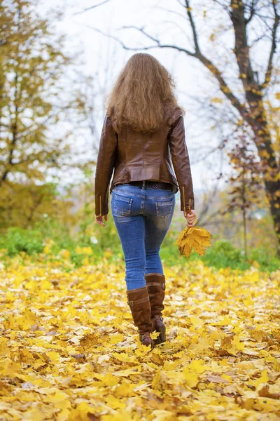 Autumn fashion image of young woman walking in the park — Stock Photo, Image