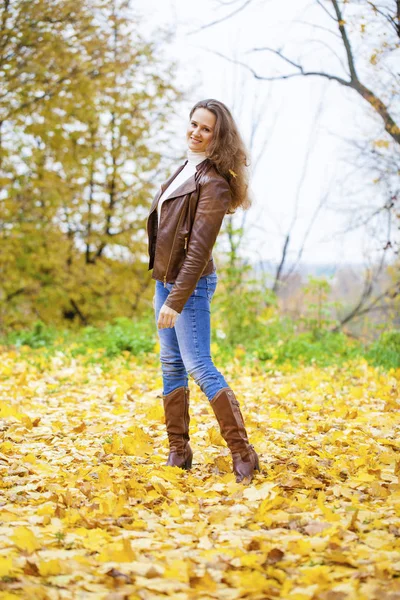 Autumn fashion image of young woman walking in the park — Stock Photo, Image