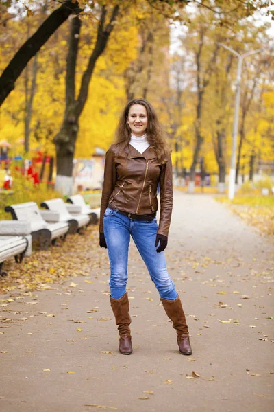 Autumn fashion image of young woman walking in the park — Stock Photo, Image