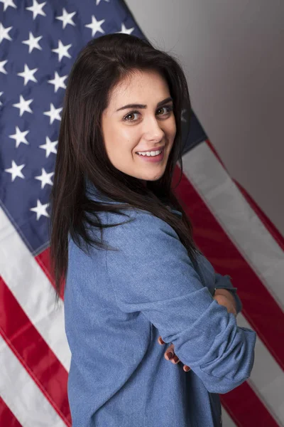 Mujer joven feliz en un fondo de la bandera americana —  Fotos de Stock