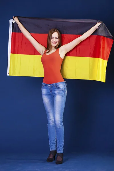 Νεαρή όμορφη γυναίκα, κρατώντας μια μεγάλη σημαία της Γερμανίας — Φωτογραφία Αρχείου