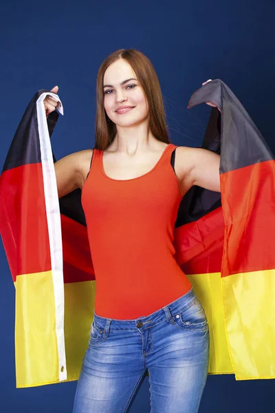 Joven hermosa mujer sosteniendo una gran bandera de Alemania — Foto de Stock