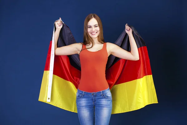 Ung vacker kvinna som håller en stor flagga Tyskland — Stockfoto