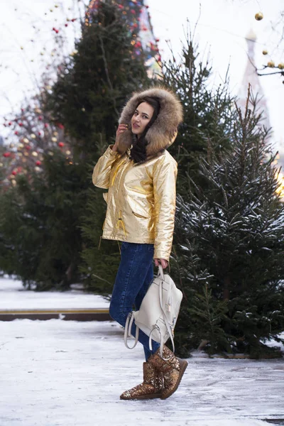 Молодая красивая женщина в золотой куртке — стоковое фото
