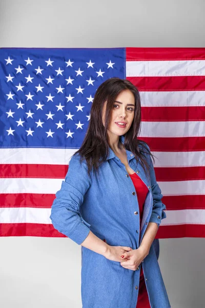 Mujer joven sosteniendo una gran bandera americana —  Fotos de Stock