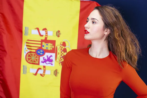 Молодая женщина на фоне испанского флага — стоковое фото
