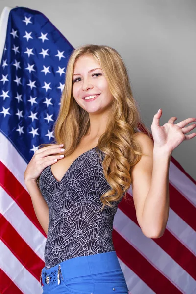 Amerikan bayrağı bir arka plan üzerinde mutlu genç kadın — Stok fotoğraf