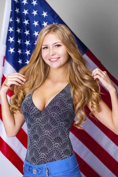 Šťastná mladá žena na pozadí americké vlajky — Stock fotografie