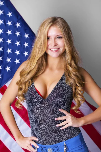 Gelukkig jonge vrouw op een achtergrond van de Amerikaanse vlag — Stockfoto