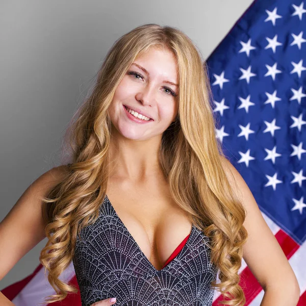 Šťastná mladá žena na pozadí americké vlajky — Stock fotografie