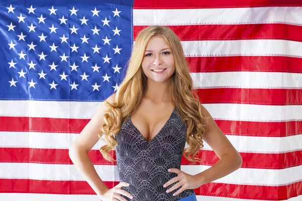 Счастливая молодая женщина на фоне американского флага — стоковое фото