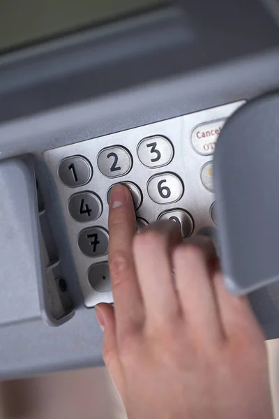 Feche o pino de entrada de mão em um ATM. Dedo prestes a pressionar um — Fotografia de Stock