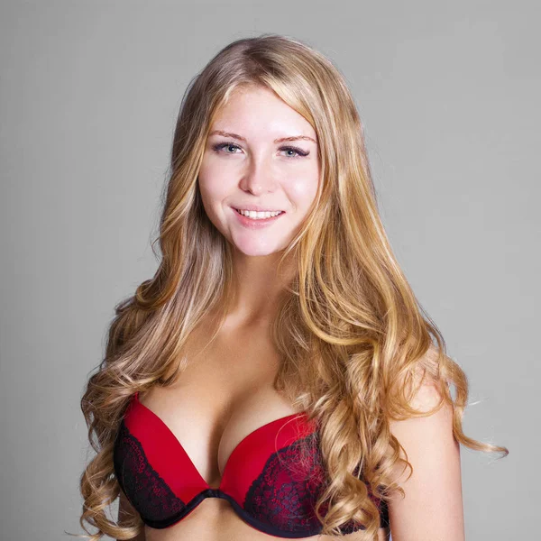 Boldog, fiatal szőke nő pózol, piros melltartó — Stock Fotó