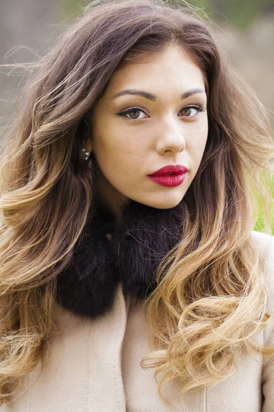 Portrait of a young beautiful woman in beige coat — Stock Photo, Image