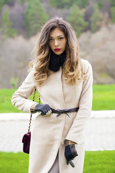 Portret van een jonge mooie vrouw in beige jas — Stockfoto