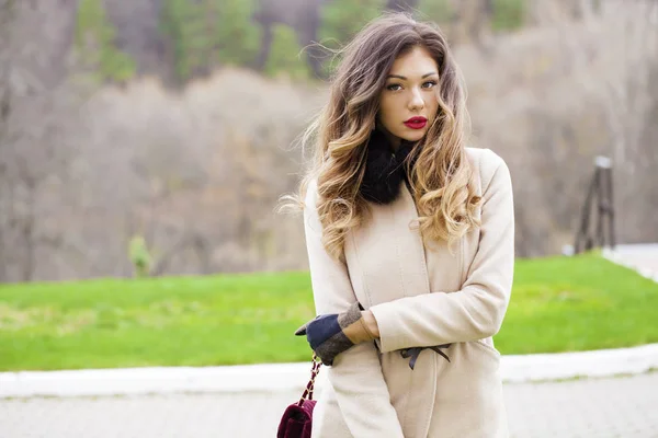 Portrait of a young beautiful woman in beige coat — Stock Photo, Image