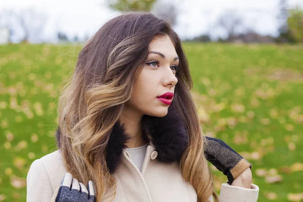 Portrait of a young beautiful woman in beige coat — Stock Photo, Image