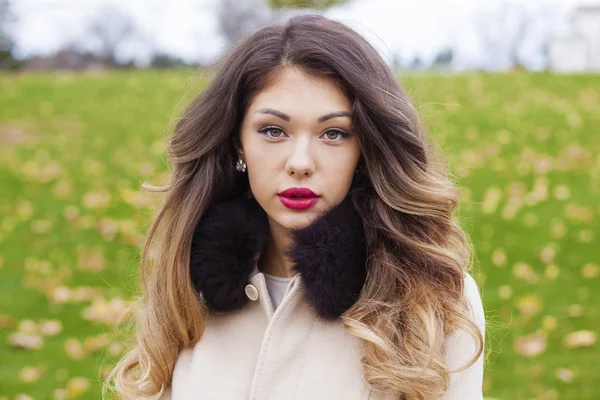 Portrait of a young beautiful woman in beige coat — Stock Photo, Image