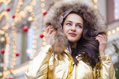 Altın ceketi giyen genç güzel kadın 